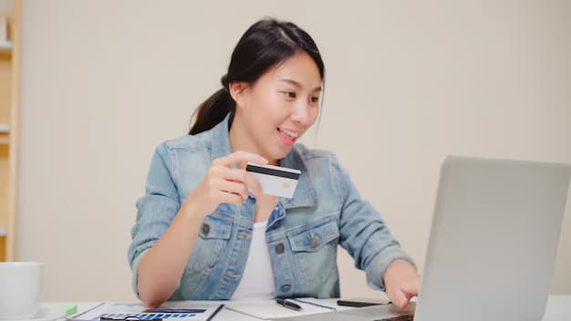 Beautiful asian woman using laptop buying online shopping by credit card while