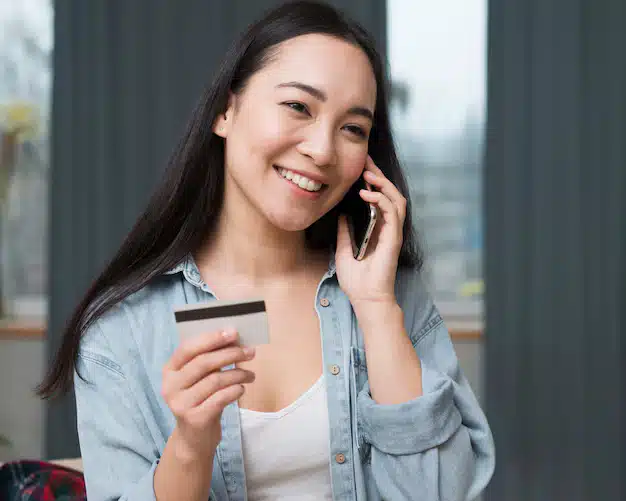 Smiley woman ordering online from her smartphone 23