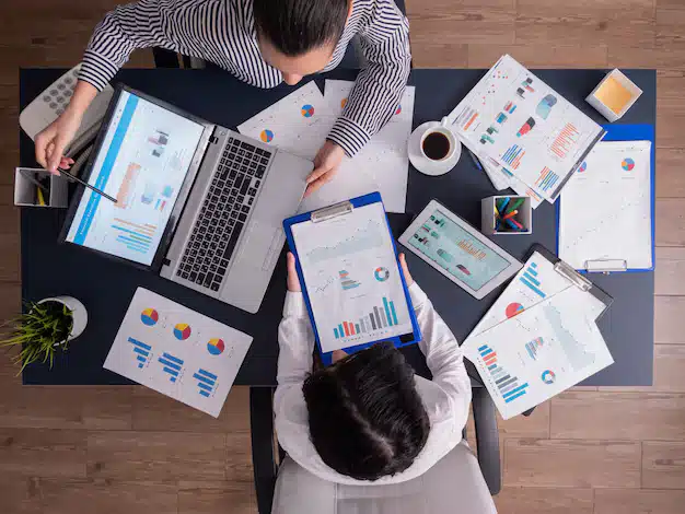 Top viewtop view manager employee doing teamwork business office looking charts laptop